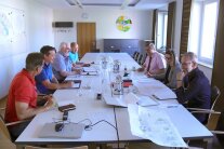 Sieben Personen sitzen an einem großen Tisch und besprechen die weiteren Schritte im Projekt Bürgerhaus Saldenburg
